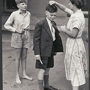 A woman combs a boy's hair at Kilmany Park Boys Home, Sale, Victoria
